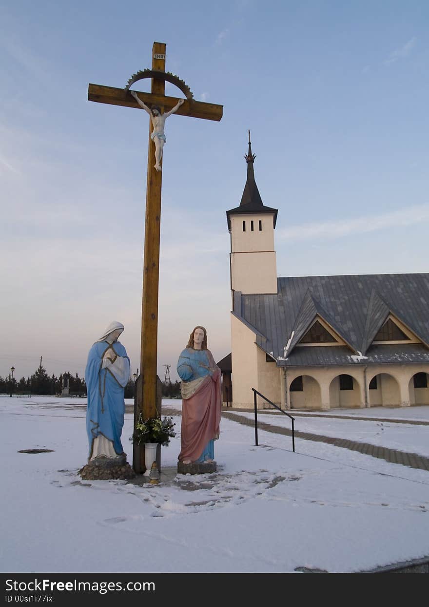 Jesus on the cross. In background small beauty church