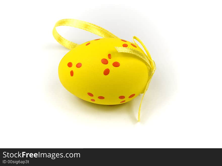 One yellow easter egg with gold ribbon isolated on white