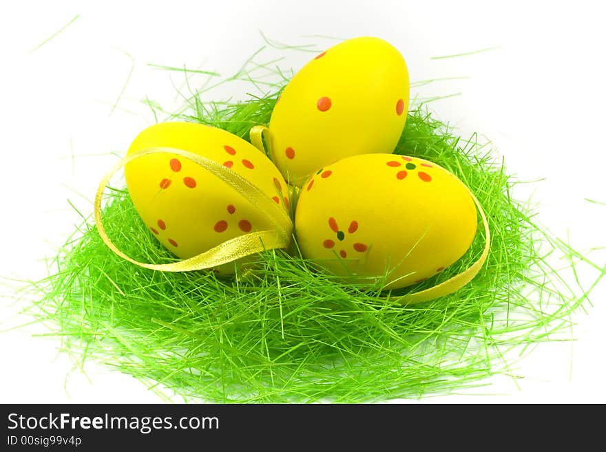 Three yellow easter eggs with green grass