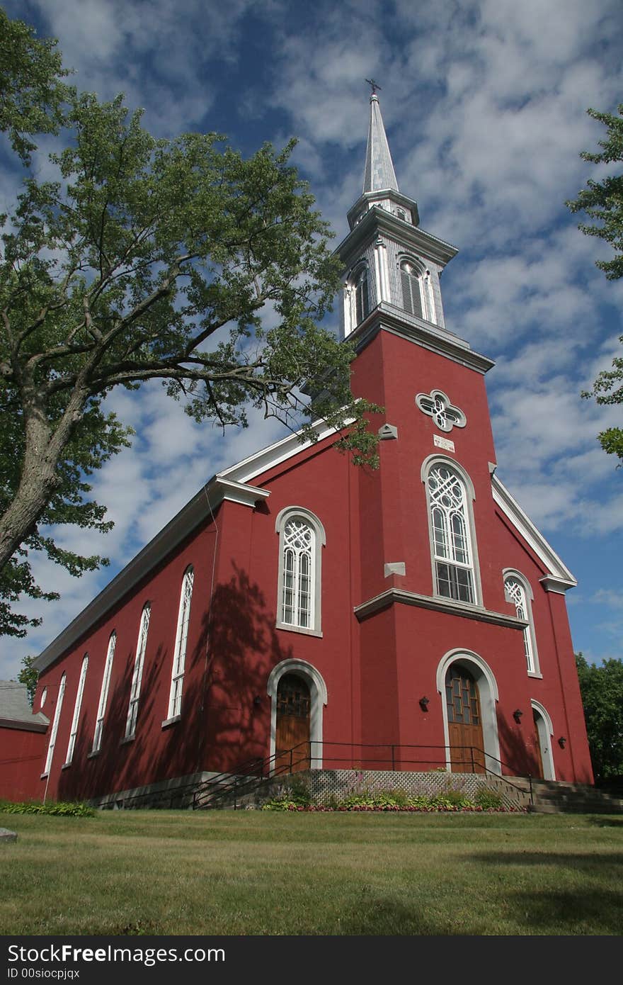 A church with red tree and sky. A church with red tree and sky