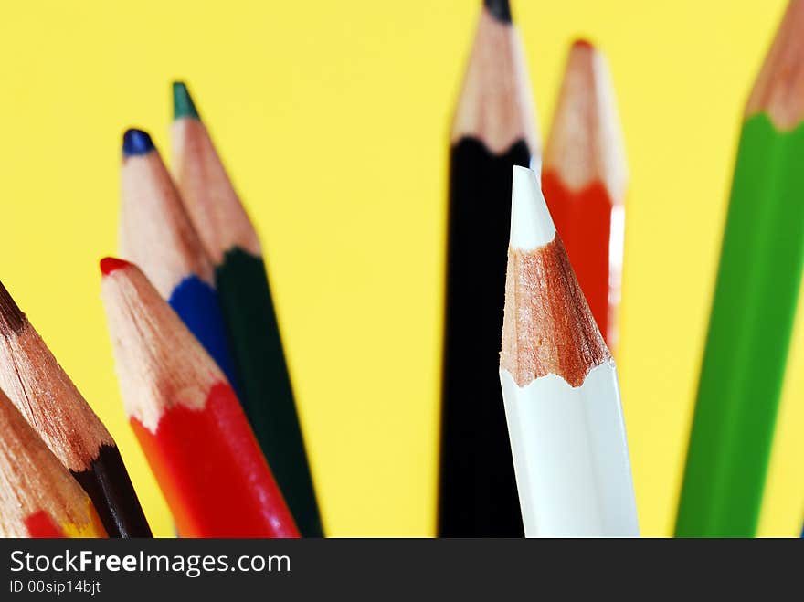 Macro shot of lots of colored pencils - focus on the white one. Macro shot of lots of colored pencils - focus on the white one