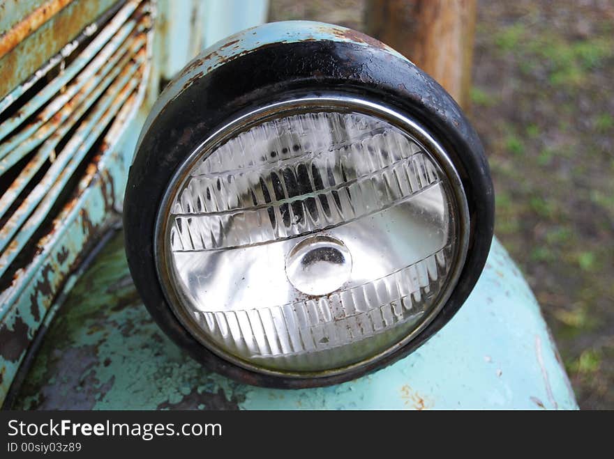 Crushed and rusted antique car frontlight view close-up. Crushed and rusted antique car frontlight view close-up