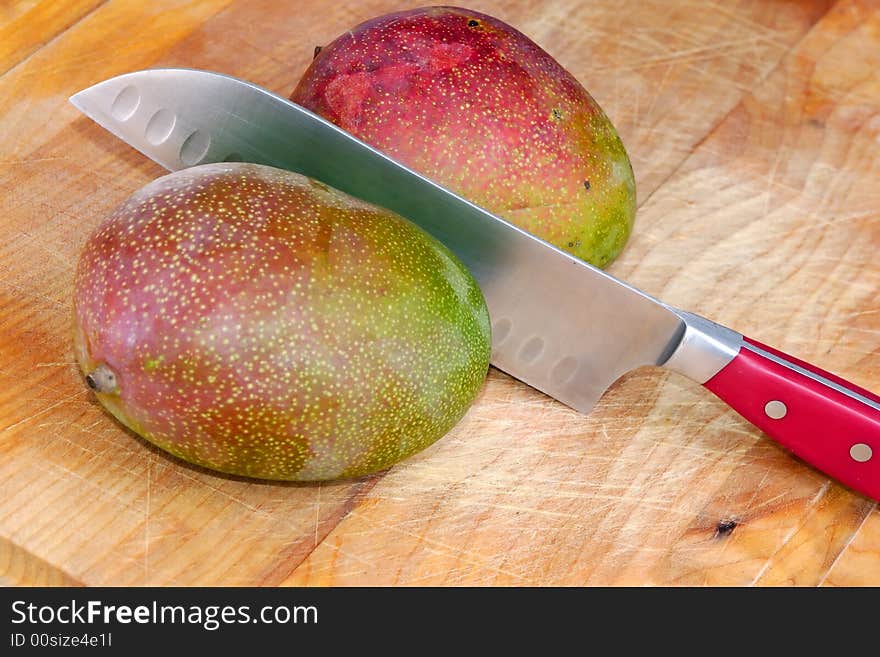 Two mangos with knife