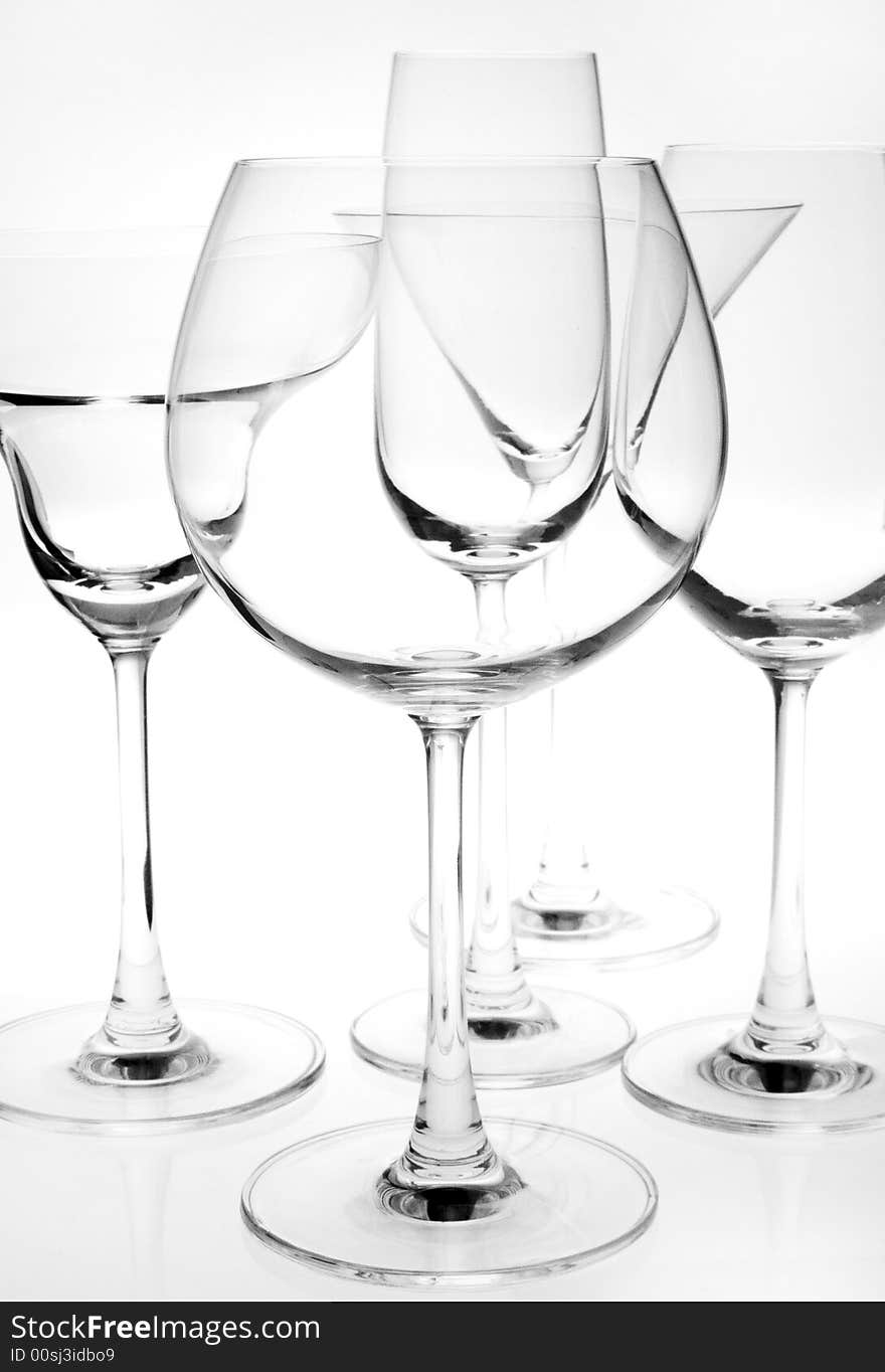 Few wine  glasses on the white back light. Few wine  glasses on the white back light