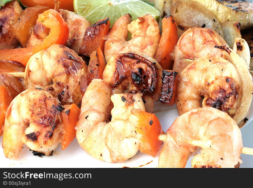 Grilled prawns on bamboo sticks served with salad