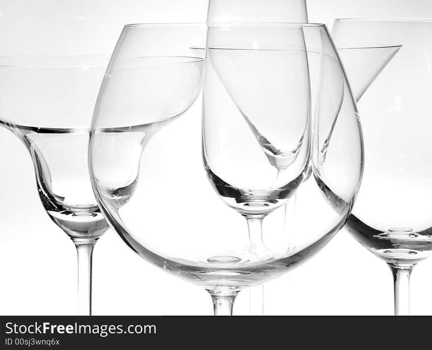 Few wine  glasses on the white back light. Few wine  glasses on the white back light