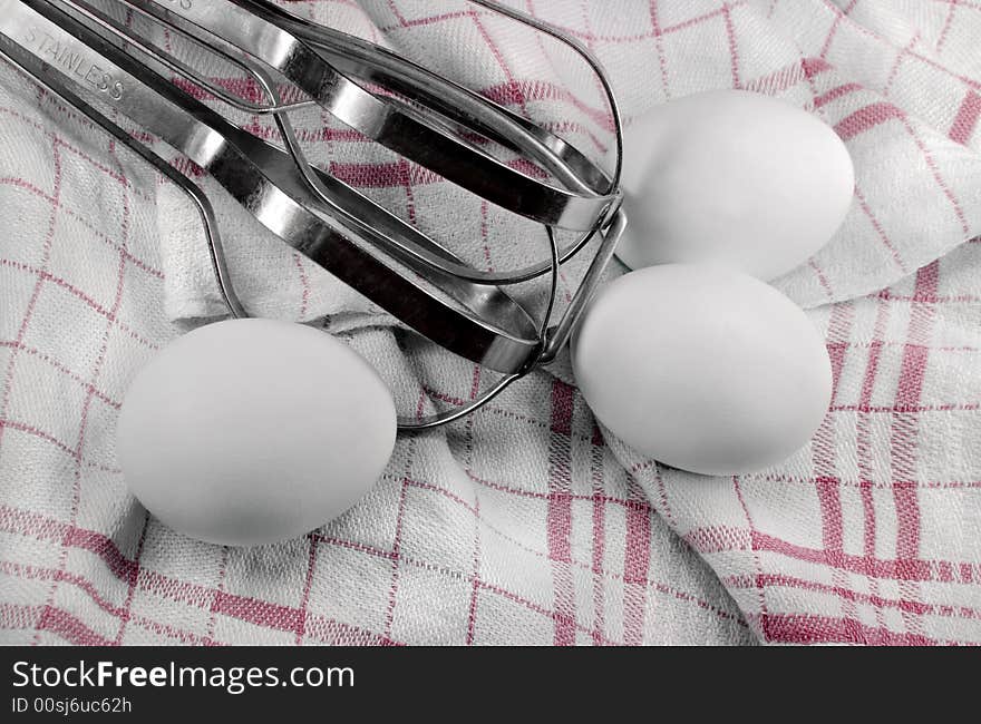 Eggs and beater on a Dish Towel.