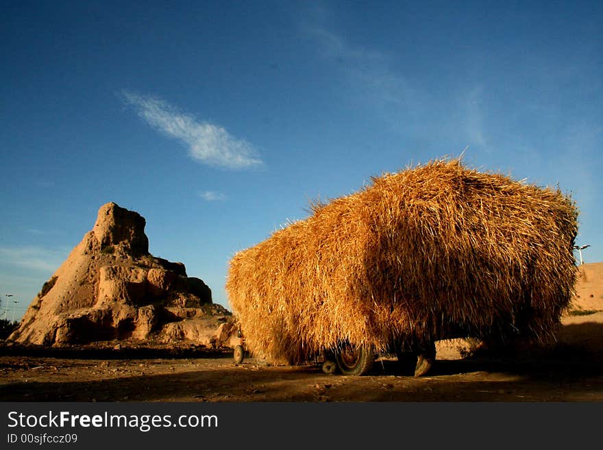 In gansu province of china, an old tractor in front of 1st centry military castle, fill up straw. In gansu province of china, an old tractor in front of 1st centry military castle, fill up straw.