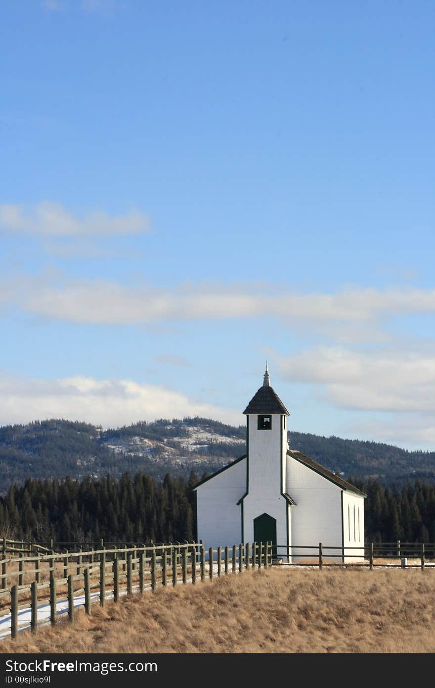 An old small country church surrounded by a wooden fence. An old small country church surrounded by a wooden fence