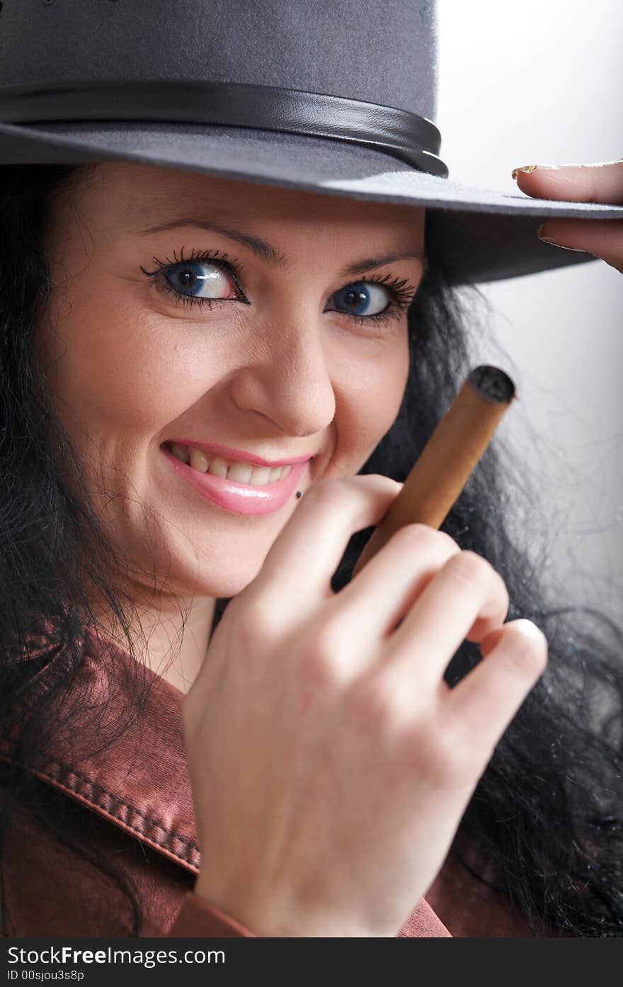 An image of a beautiful woman in felt hat with cigar. An image of a beautiful woman in felt hat with cigar