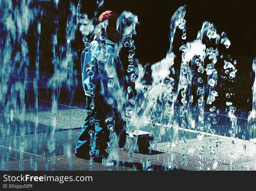 A child playing with moving sensor that trigger different water fountains. A child playing with moving sensor that trigger different water fountains