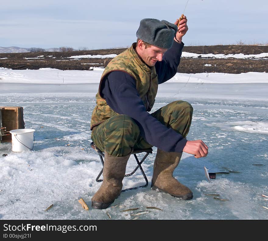 A winter fishing on river. People is fishing the smelt. Russian Far East, Primorye, Kievka river. A winter fishing on river. People is fishing the smelt. Russian Far East, Primorye, Kievka river.