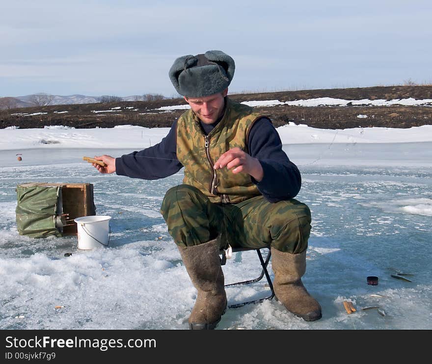 A winter fishing on river. People is fishing the smelt. Russian Far East, Primorye, Kievka river. A winter fishing on river. People is fishing the smelt. Russian Far East, Primorye, Kievka river.