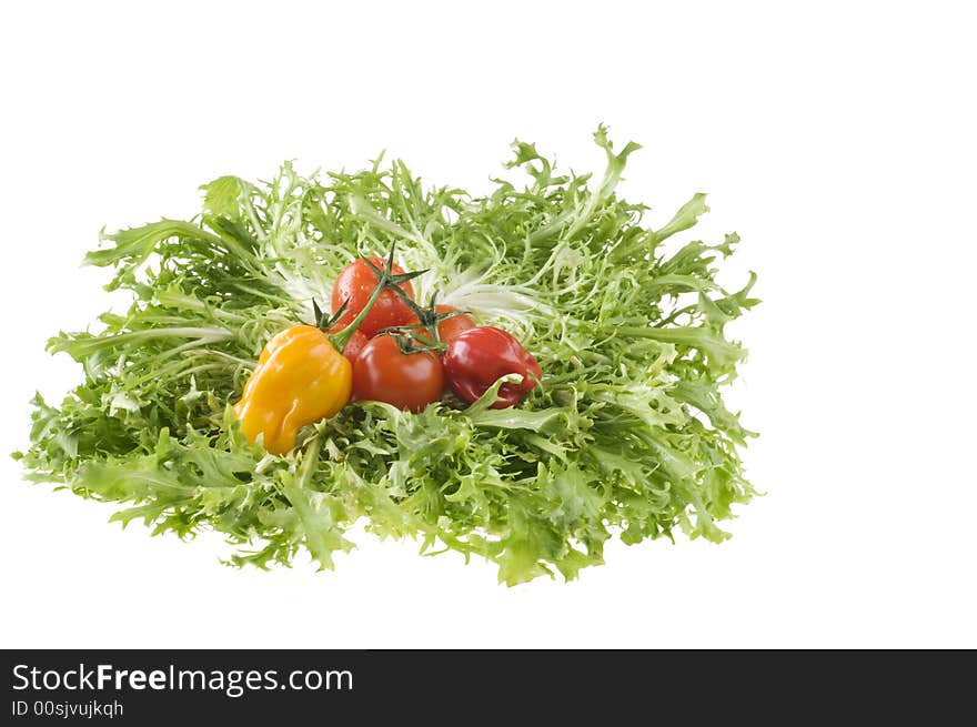 Hot color peppers and red ripe tomatoes on green leaf lettuce isolated over white background. Hot color peppers and red ripe tomatoes on green leaf lettuce isolated over white background