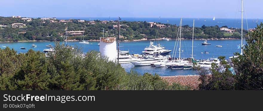 Panorama image of seaside town with beautiful luxury vacation homes, Mediterranean vegetatios and yachts in the bay. Panorama image of seaside town with beautiful luxury vacation homes, Mediterranean vegetatios and yachts in the bay