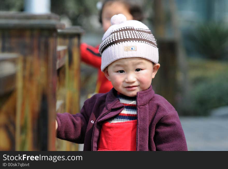 A little boy  wears new coat and hat enjoying the sunshine in spring. A little boy  wears new coat and hat enjoying the sunshine in spring.