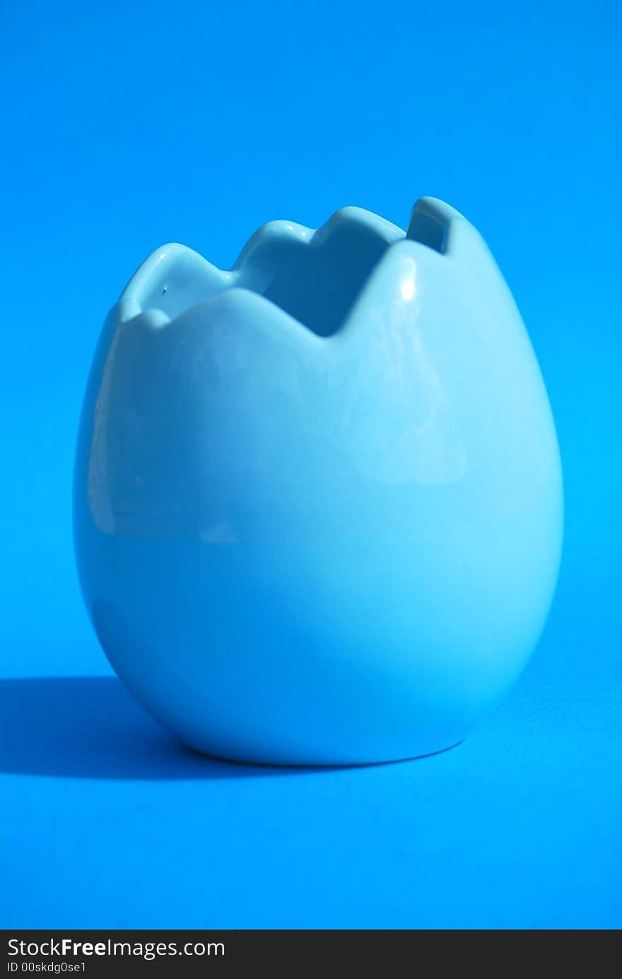 A blue egg shell on a blue background. A blue egg shell on a blue background