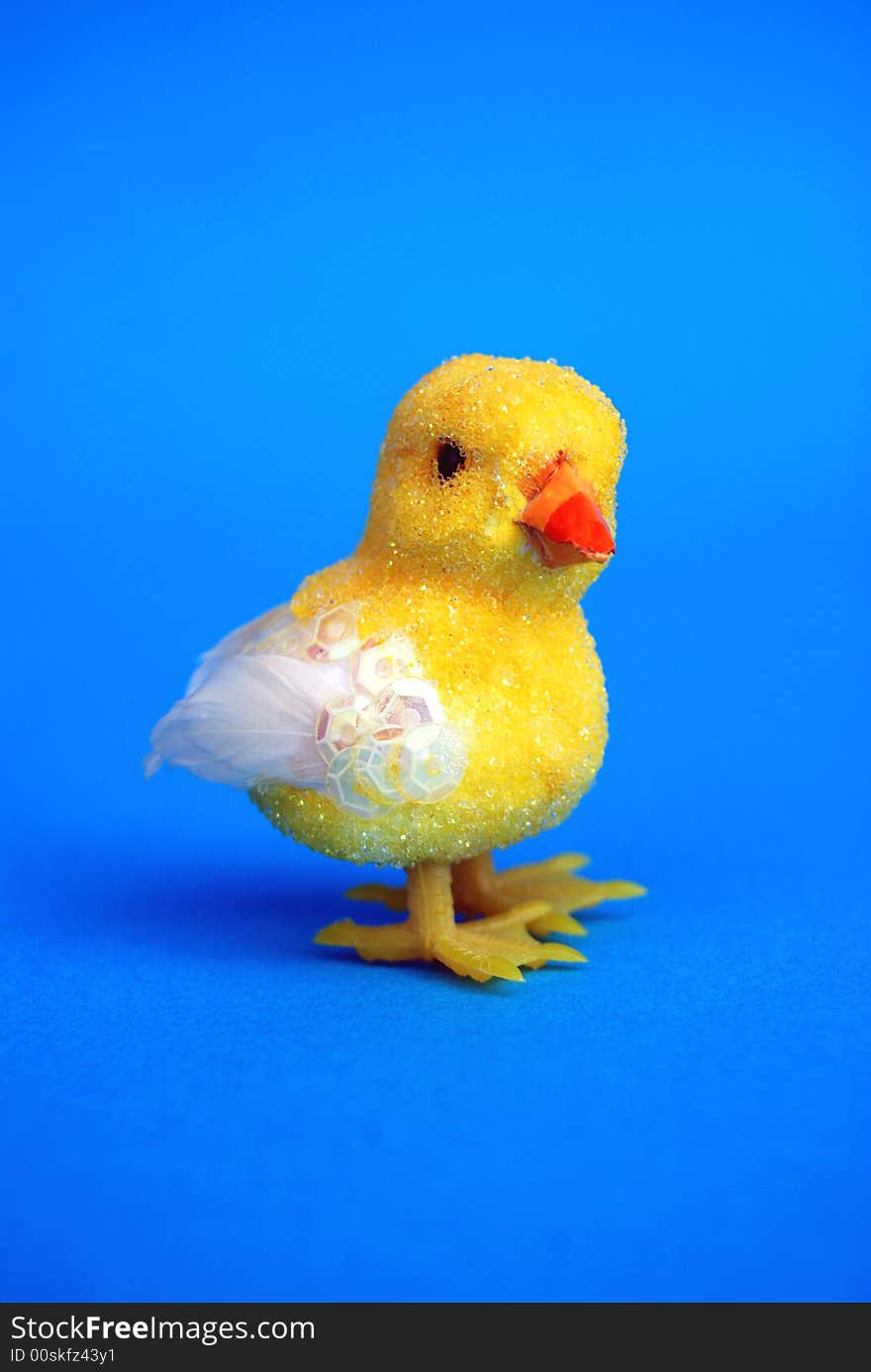 A yellow easter toy chick on blue background