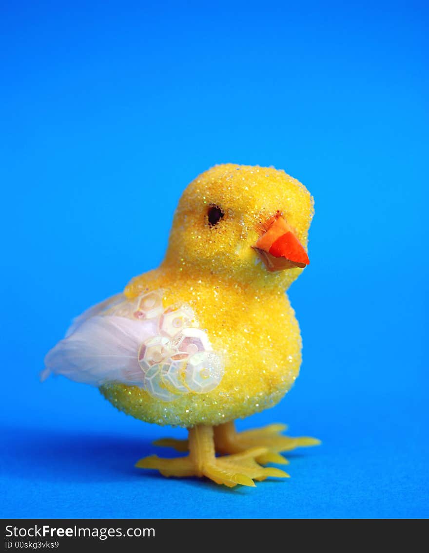 A yellow easter toy chick on blue background