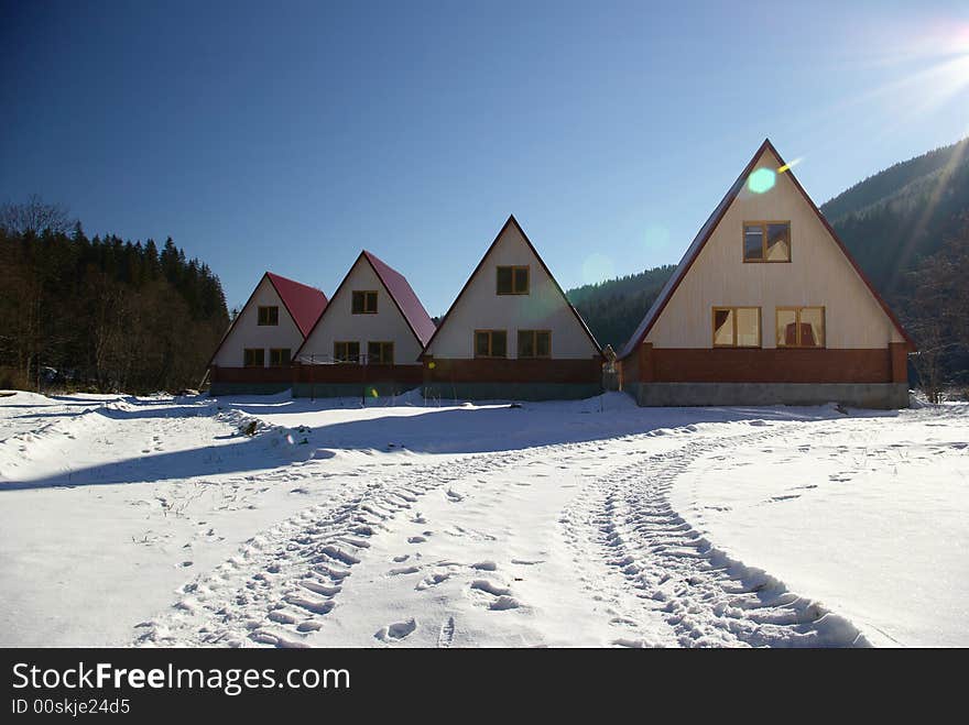 Four small houses stand on a solar glade. Four small houses stand on a solar glade