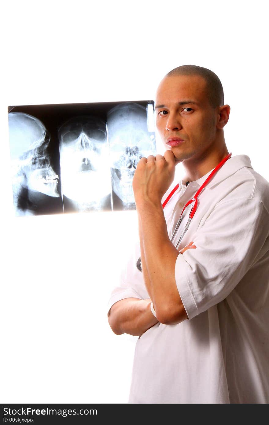 A young and handsome doctor with x-rays of a skull in the background. A young and handsome doctor with x-rays of a skull in the background.