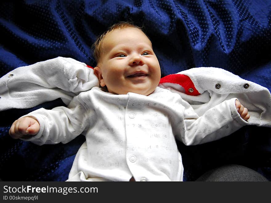 A small baby lying on a blue sheet. A small baby lying on a blue sheet