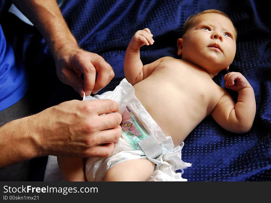 A small baby lying on a blue sheet. A small baby lying on a blue sheet