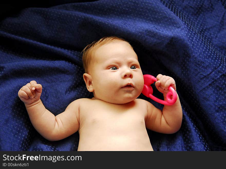 A small baby lying on a blue sheet. A small baby lying on a blue sheet