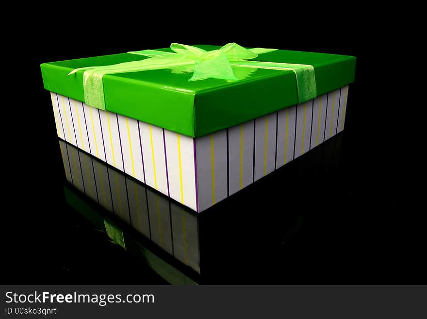 A green gift box standing on the glass