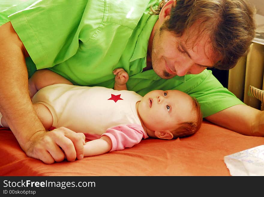 A small baby having father's finger. A small baby having father's finger