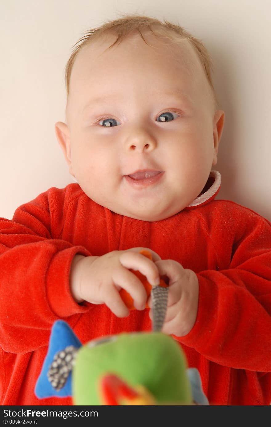 A baby in red with a toy