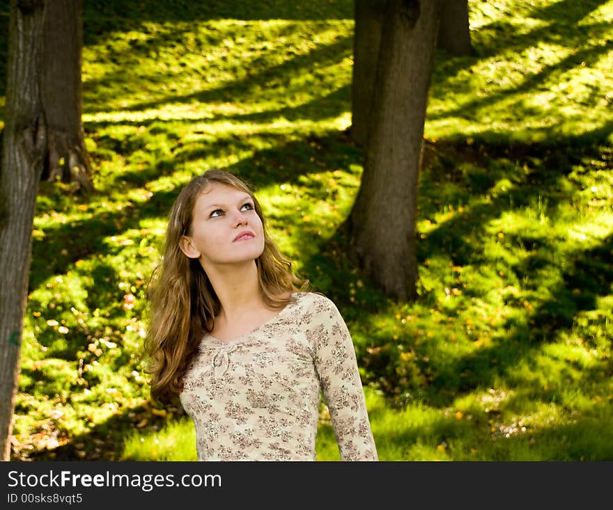 Young girl lookihg up in the forest