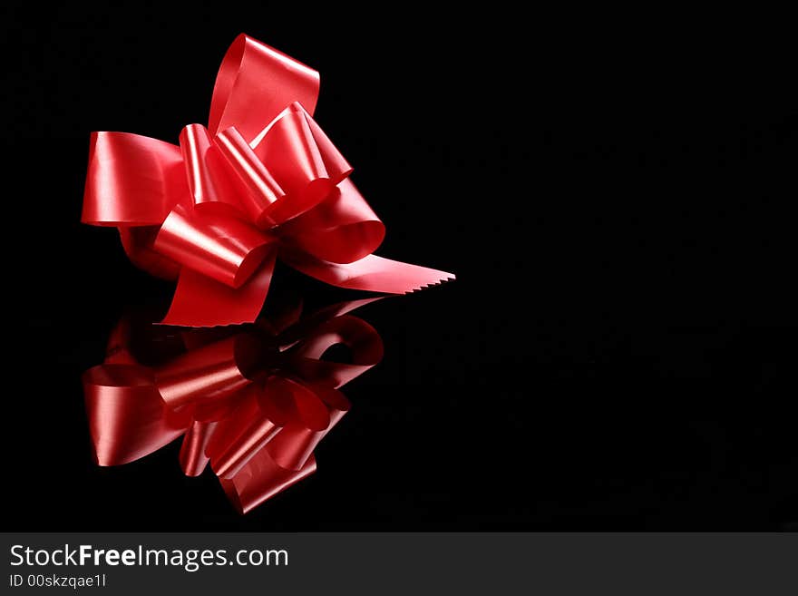 Red bow standing on a black with reflections2