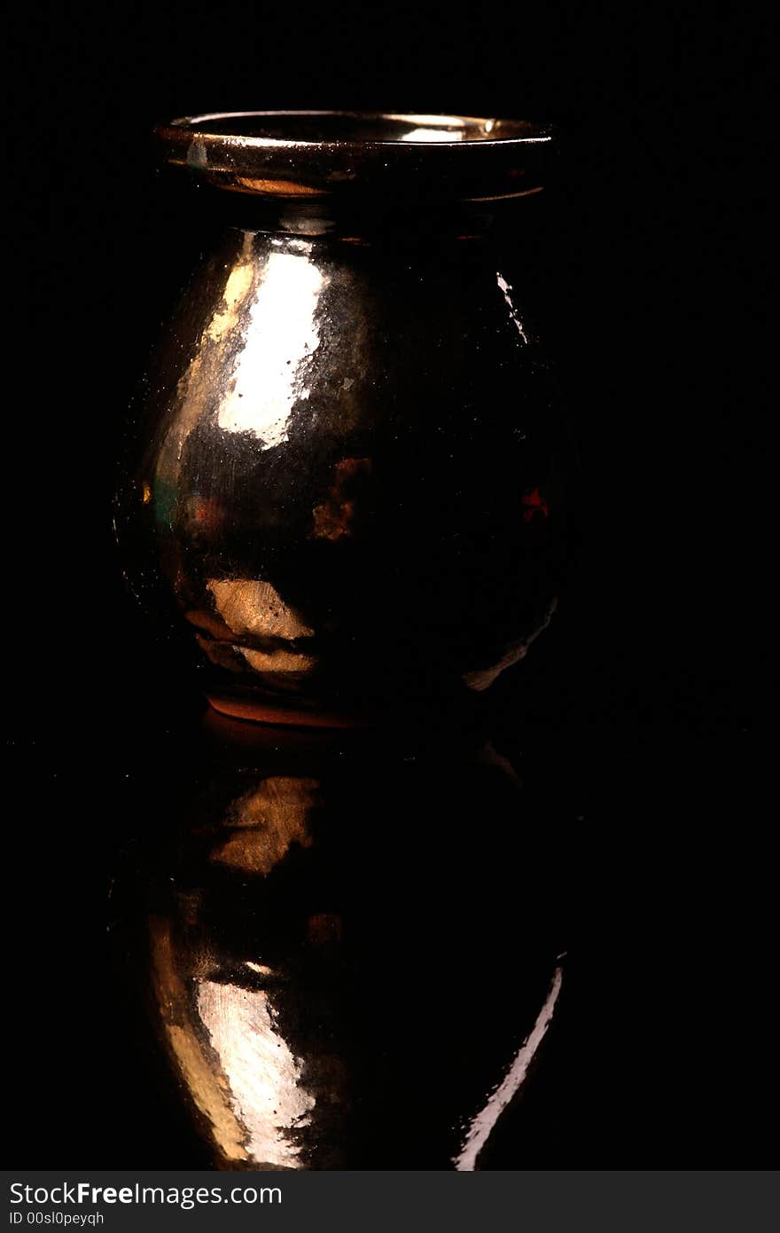 Little metallic vase standing on the black