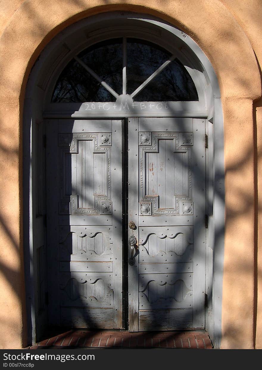 Church door shadowed by image of a tree. Church door shadowed by image of a tree.