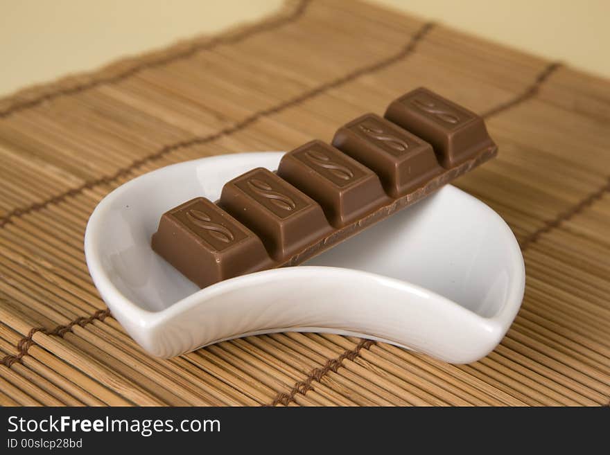 Chocolate in white cup on brown background