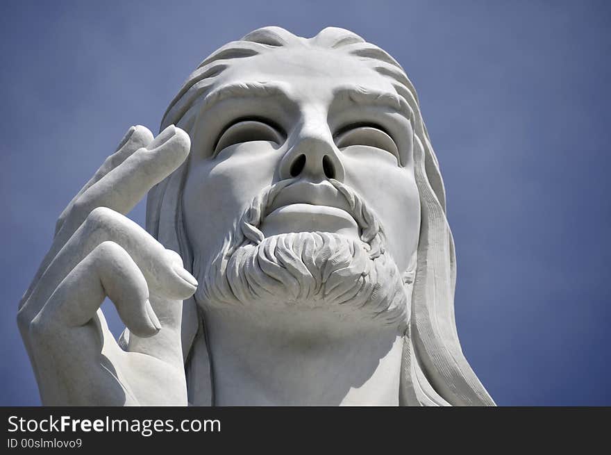 Jesus Christ statue against blue sky