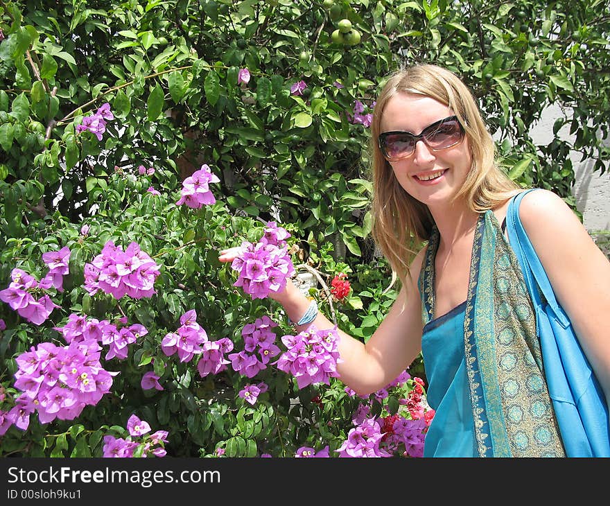 The beautiful girl is smelling flowers of bougainvillea. The beautiful girl is smelling flowers of bougainvillea