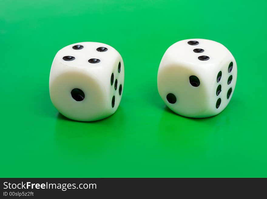 Two gambling dices on green background