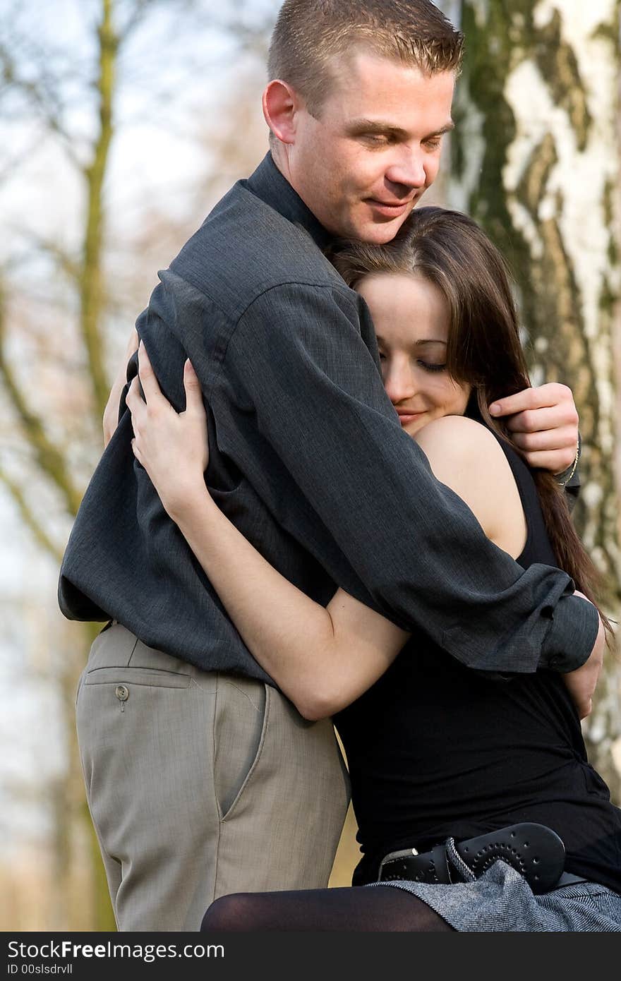 Man and girlfriend on a bench in a park caring. Man and girlfriend on a bench in a park caring