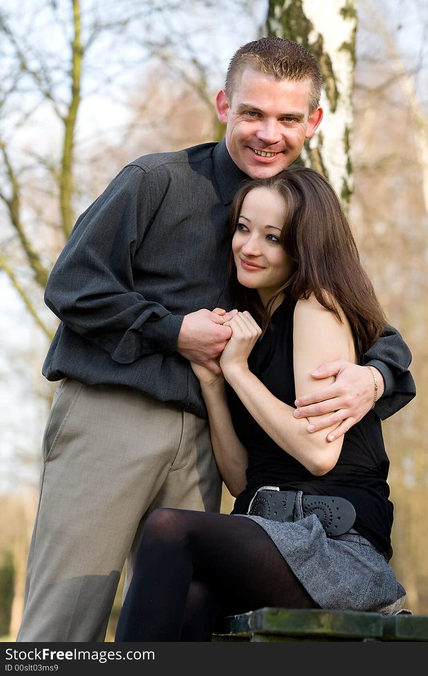 Man and girlfriend on a bench in a park caring. Man and girlfriend on a bench in a park caring