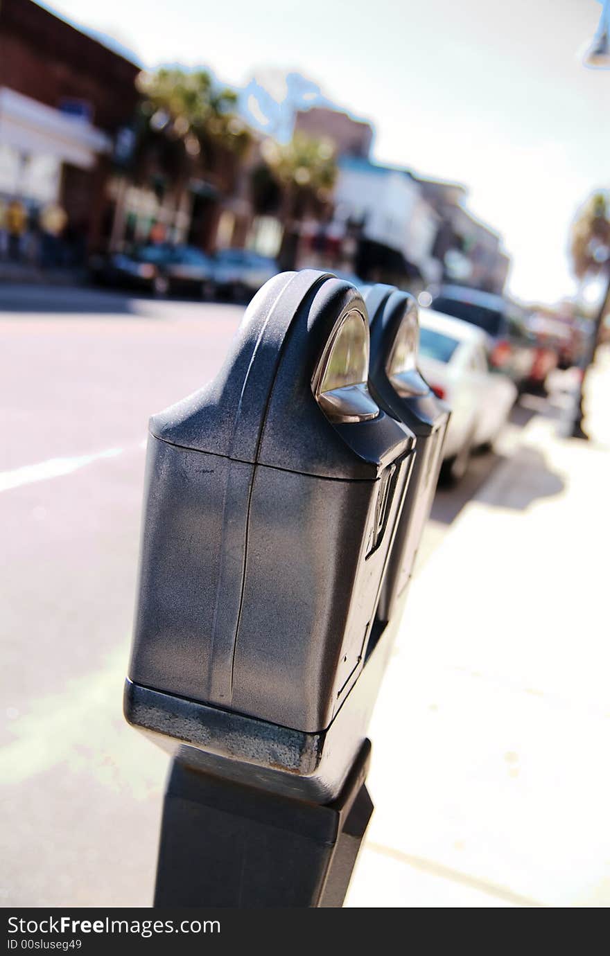 A parking meter on the side of a street in a busy downtown. A parking meter on the side of a street in a busy downtown.