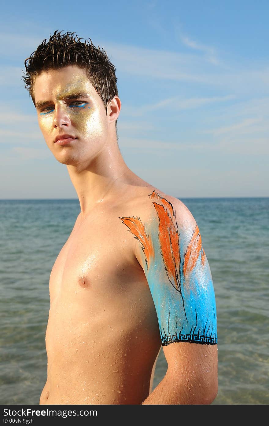 Young model on the beach wearing artistic bodypaint drawing. Young model on the beach wearing artistic bodypaint drawing