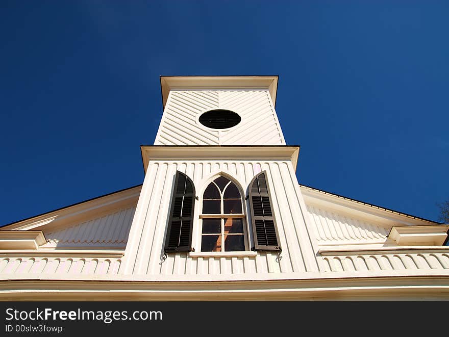 An old church steeple in front of a blue sky. An old church steeple in front of a blue sky.