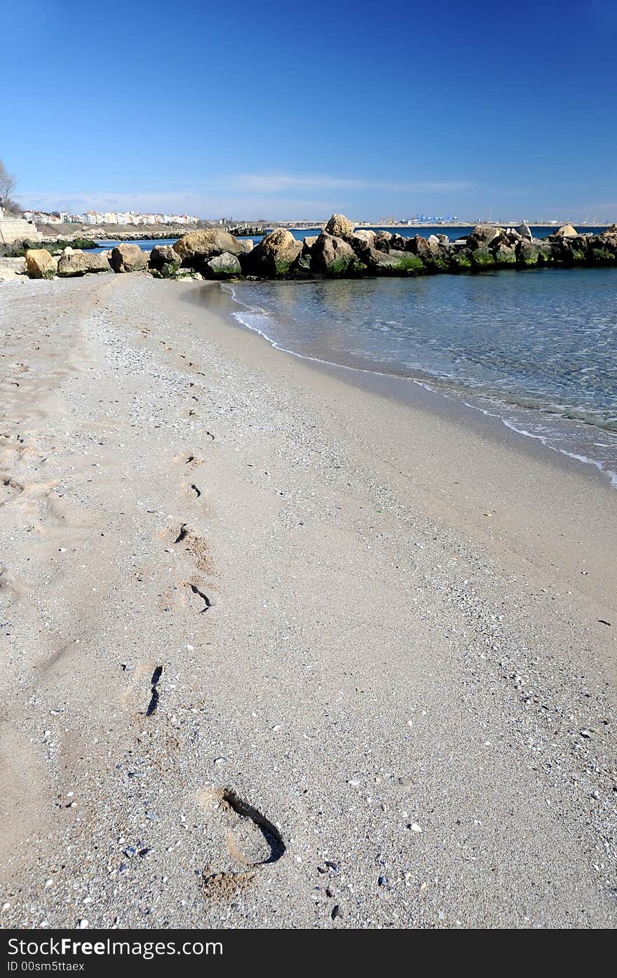 Footprints on the beach being washed away by the waves