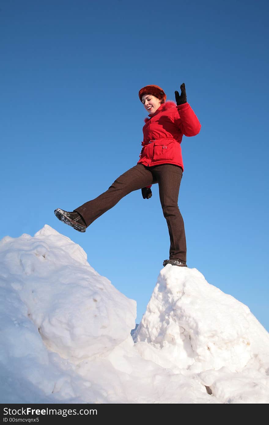 The woman steps from one snowy chunk to another