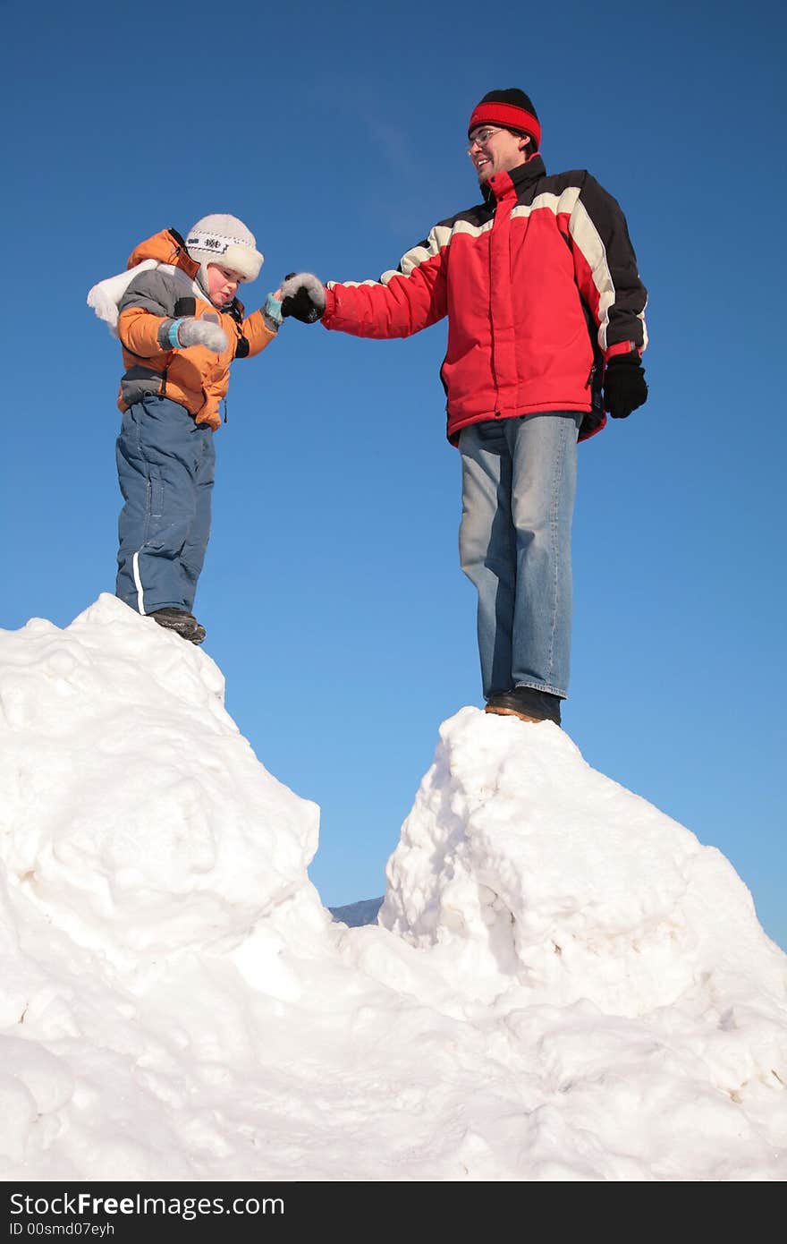 The father with child stand on snow hill