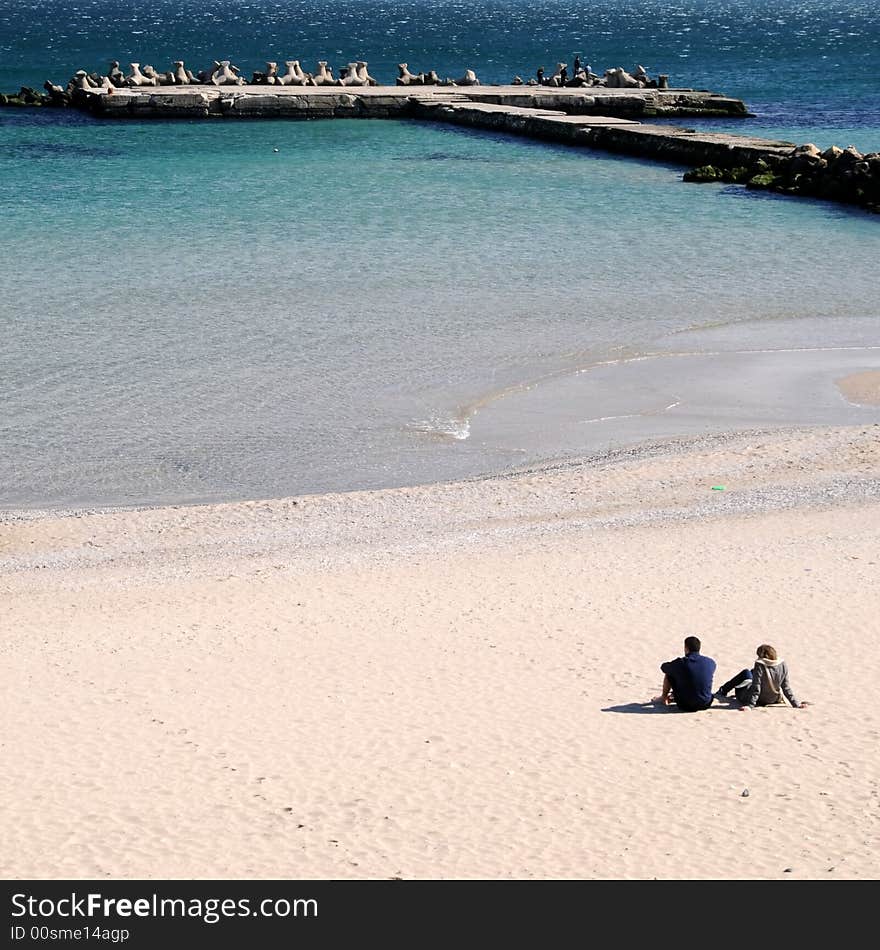 Couple sitting by the ocean