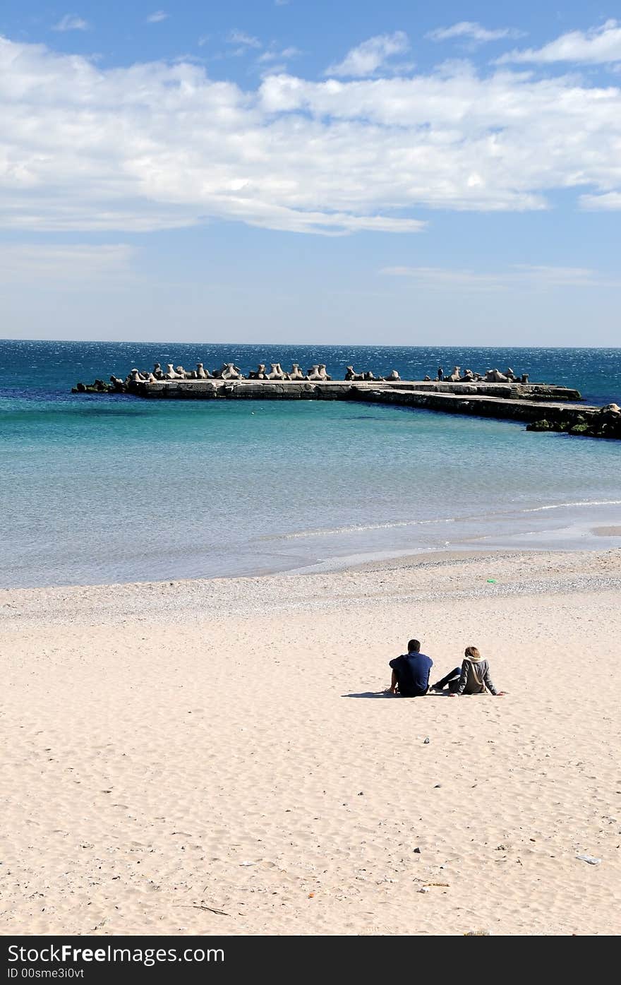 Couple sitting by the ocean