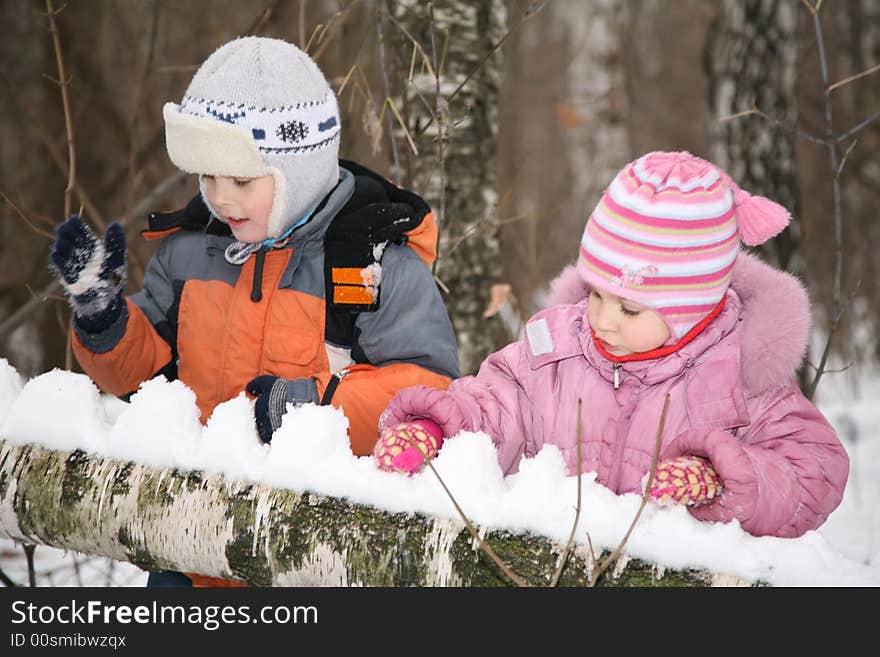 Boy and girl paly in forest in winter